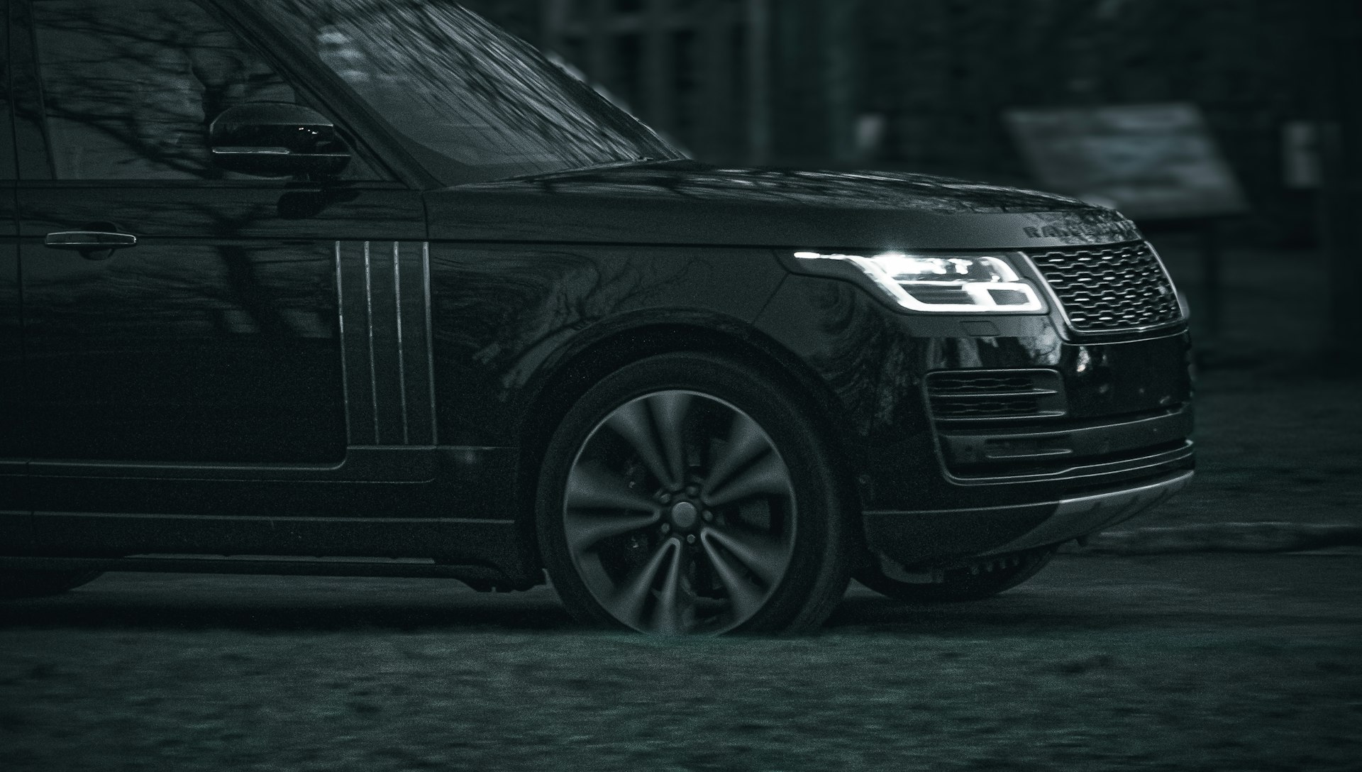Premium SUV lit at night on wet tarmac